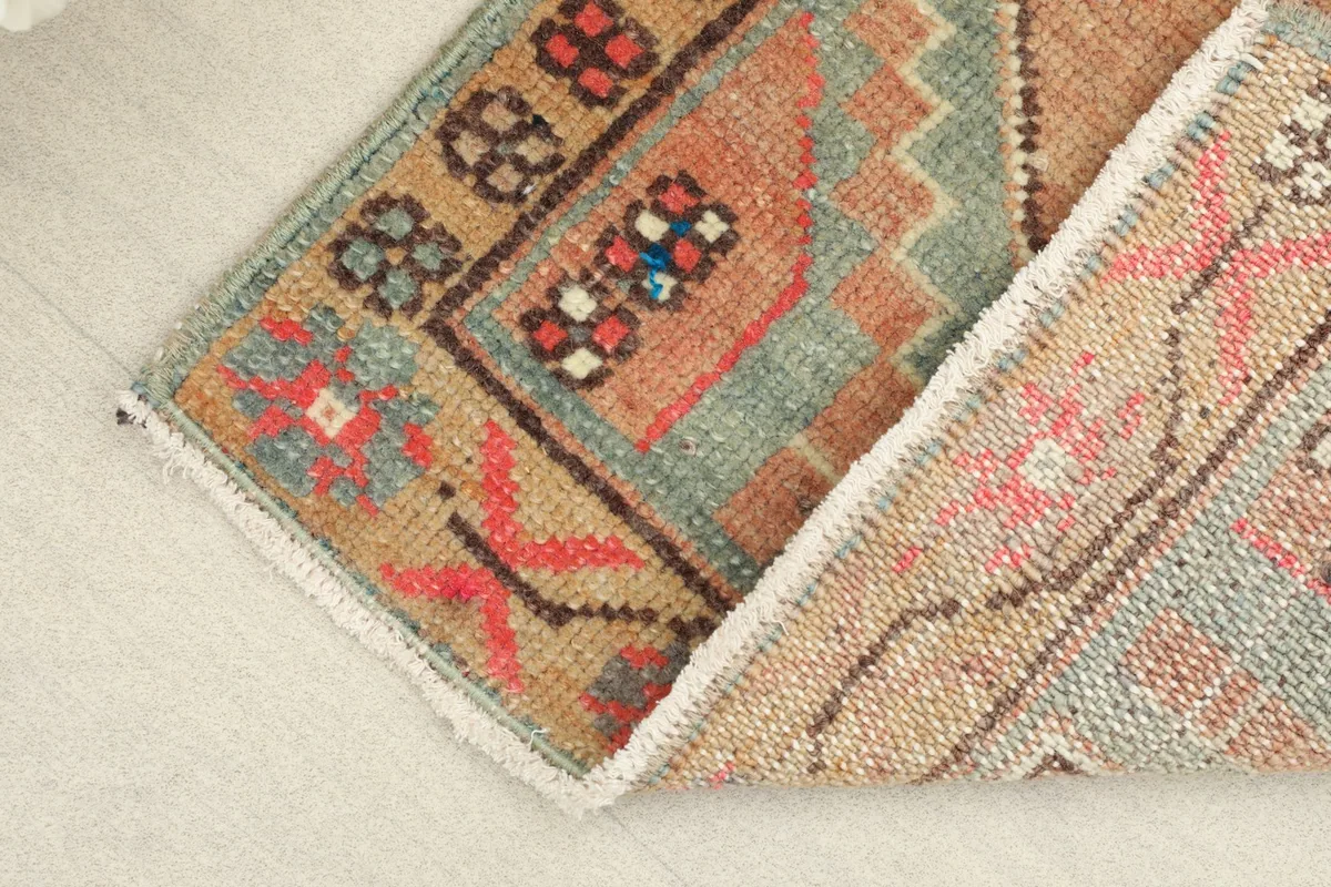 View of the rug folded, showing the cotton foundation and the reverse side's weave.