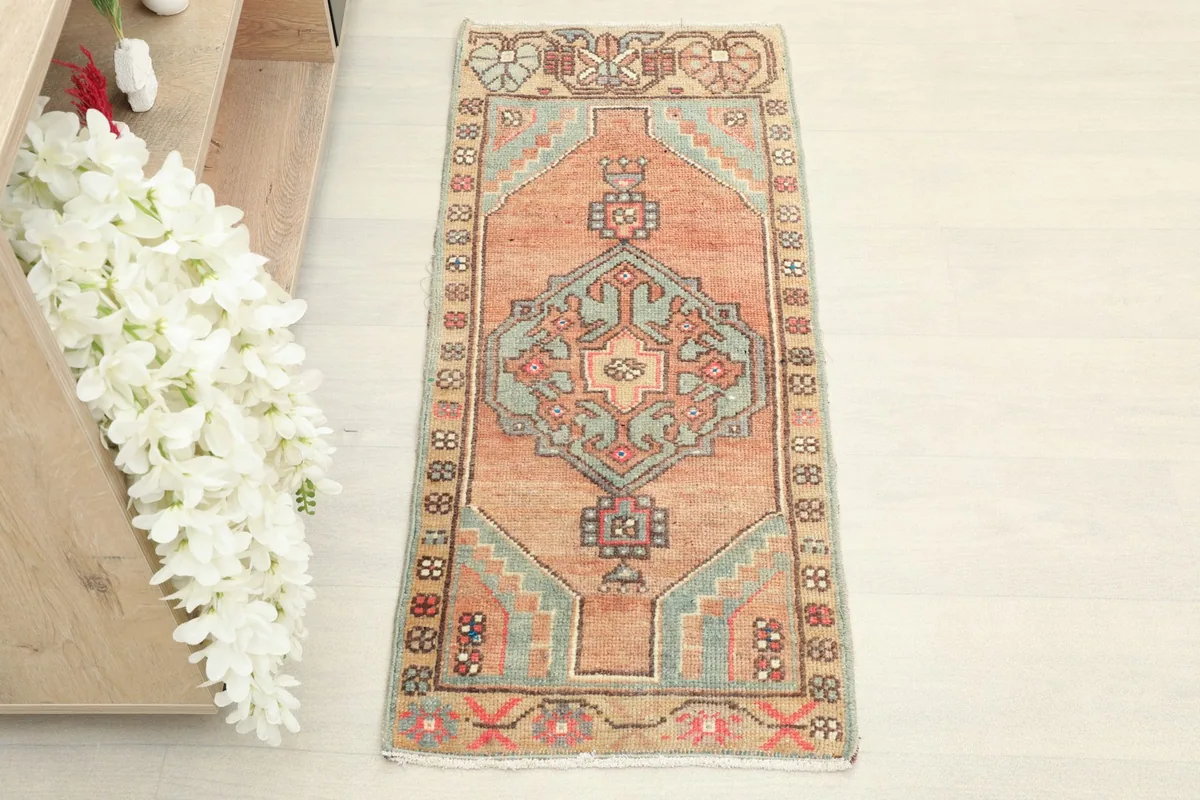 Overhead view of the 1'5" x 3'4" hand-knotted rug, highlighting its rust field and blue geometric design.