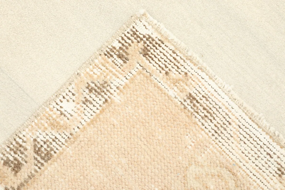 Close-up of a corner of the rug, showing the wool pile and cotton foundation.