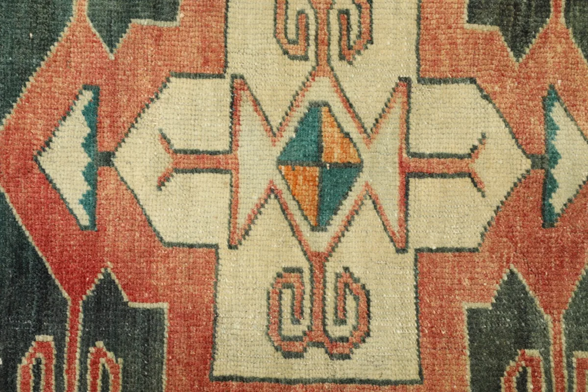 Detailed close-up of a central ivory and rust geometric medallion with blue and gold accents