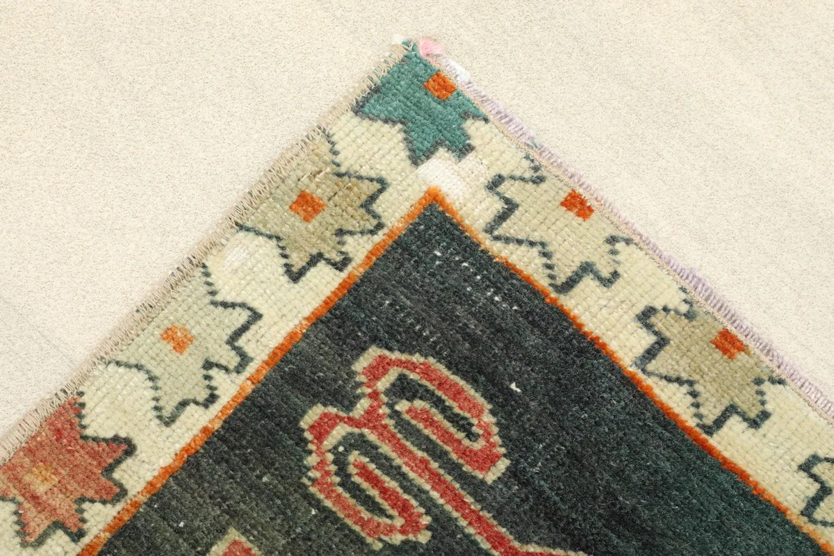Corner detail showing the ivory border with small colorful star-like motifs