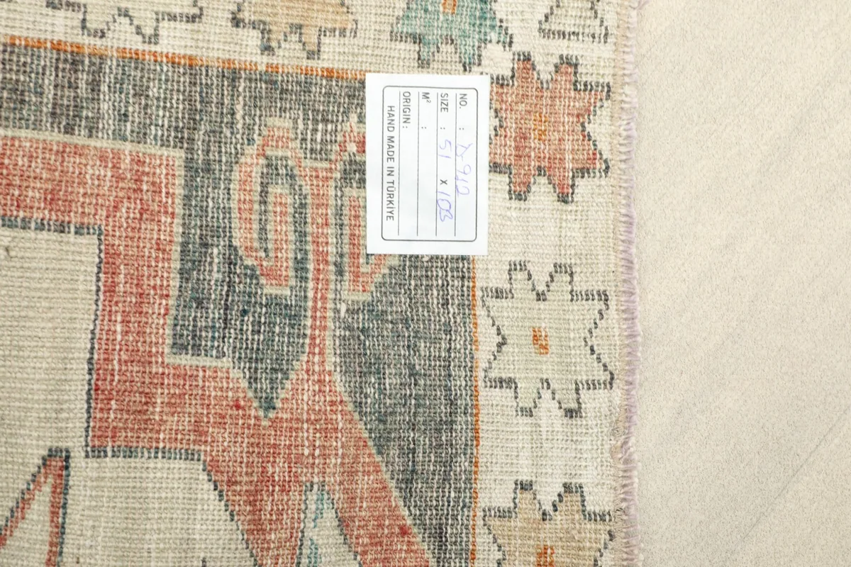 Back of the rug, showing the knotting structure and a product label