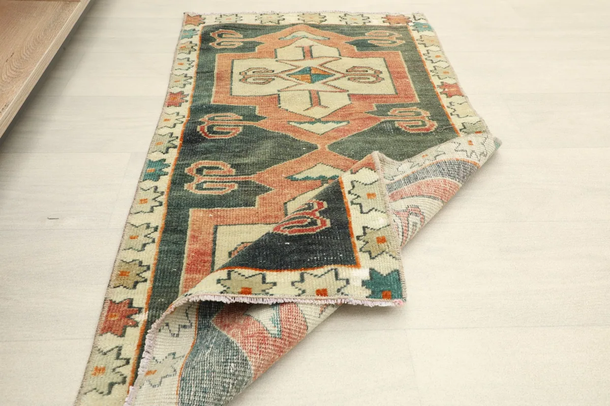 Rug partially folded, demonstrating its flexibility and the texture of the vintage wool