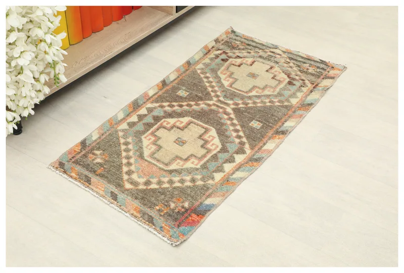 Full top view of the 1'8" x 3'5" charcoal and beige tribal doormat on a white background