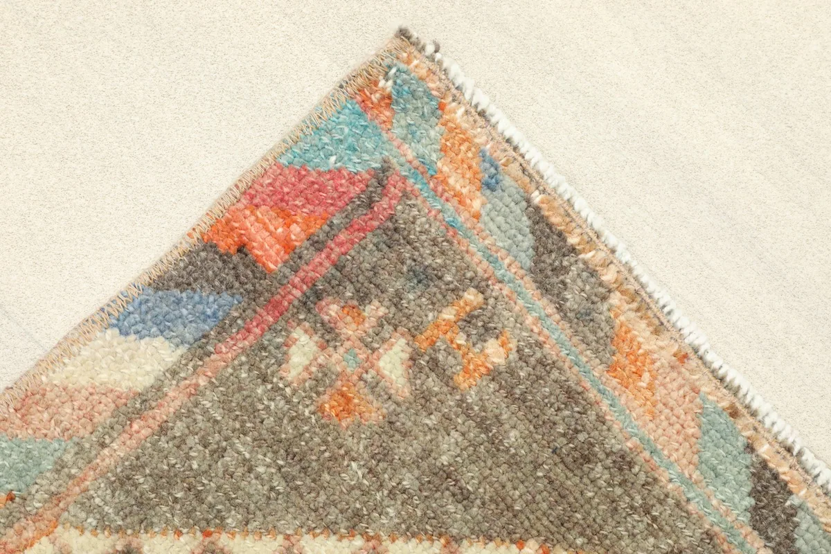 Folded corner showing the rug's thickness and the intricate weaving on the reverse side