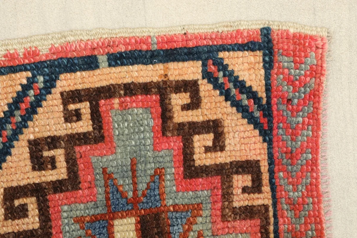 Close-up of the upper right corner, detailing the rose border and beige field with navy accents.