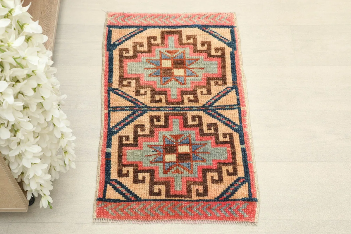 Overhead view showcasing the beige field and geometric patterns in rose, navy, and green.