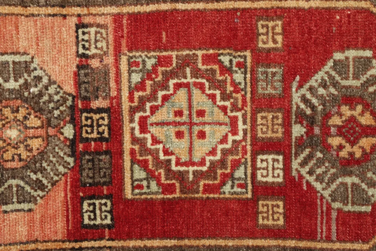 Detailed view of the red field and a central geometric medallion-like design.