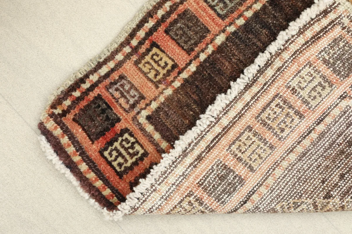 View of the back of the hand-knotted rug, revealing the cotton foundation and knotting.