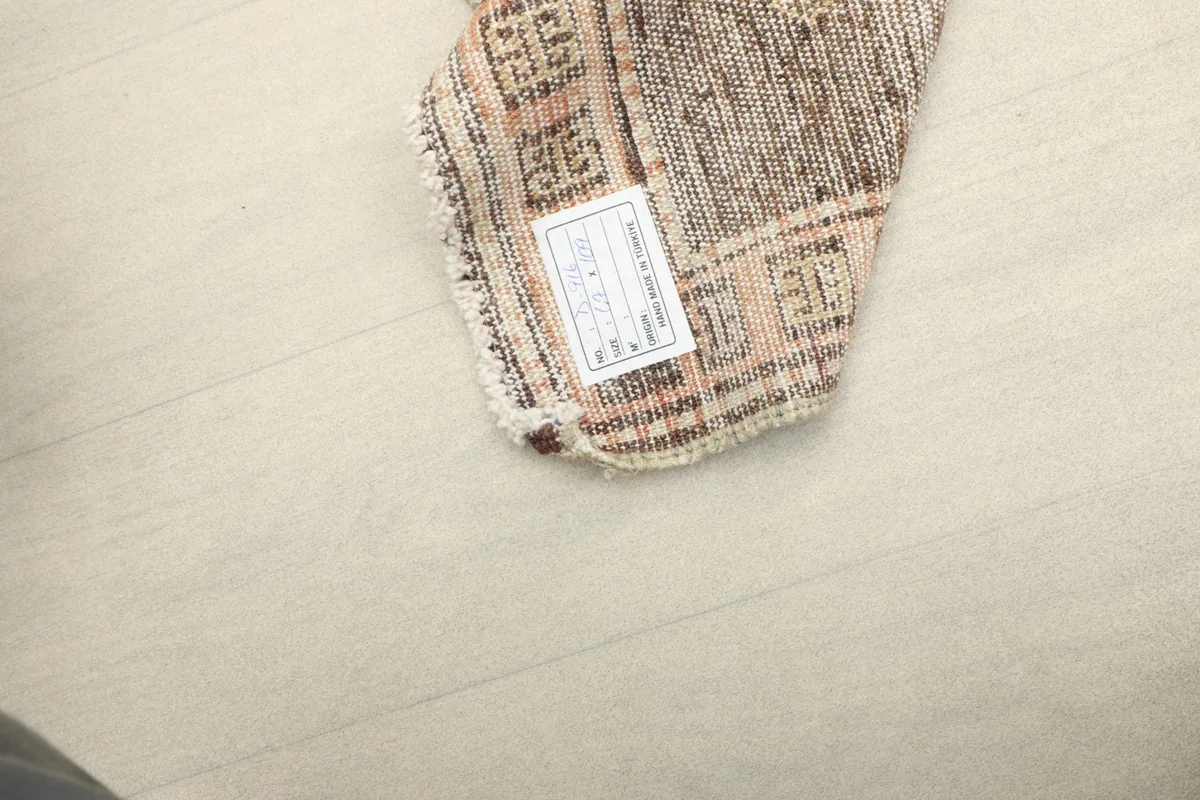 Underside of a corner with a product label, showing the rug's construction.