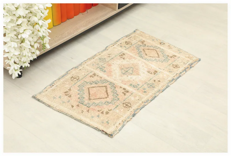 Full top view of the beige and rose geometric vintage doormat on a white background.