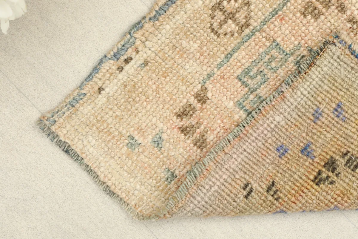 View of the rug folded to show the thickness of the wool pile and the cotton foundation.