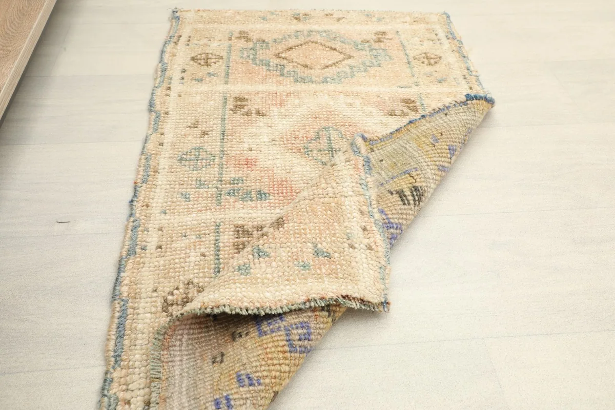 The rug partially folded, revealing the reverse side's weave and the overall construction.