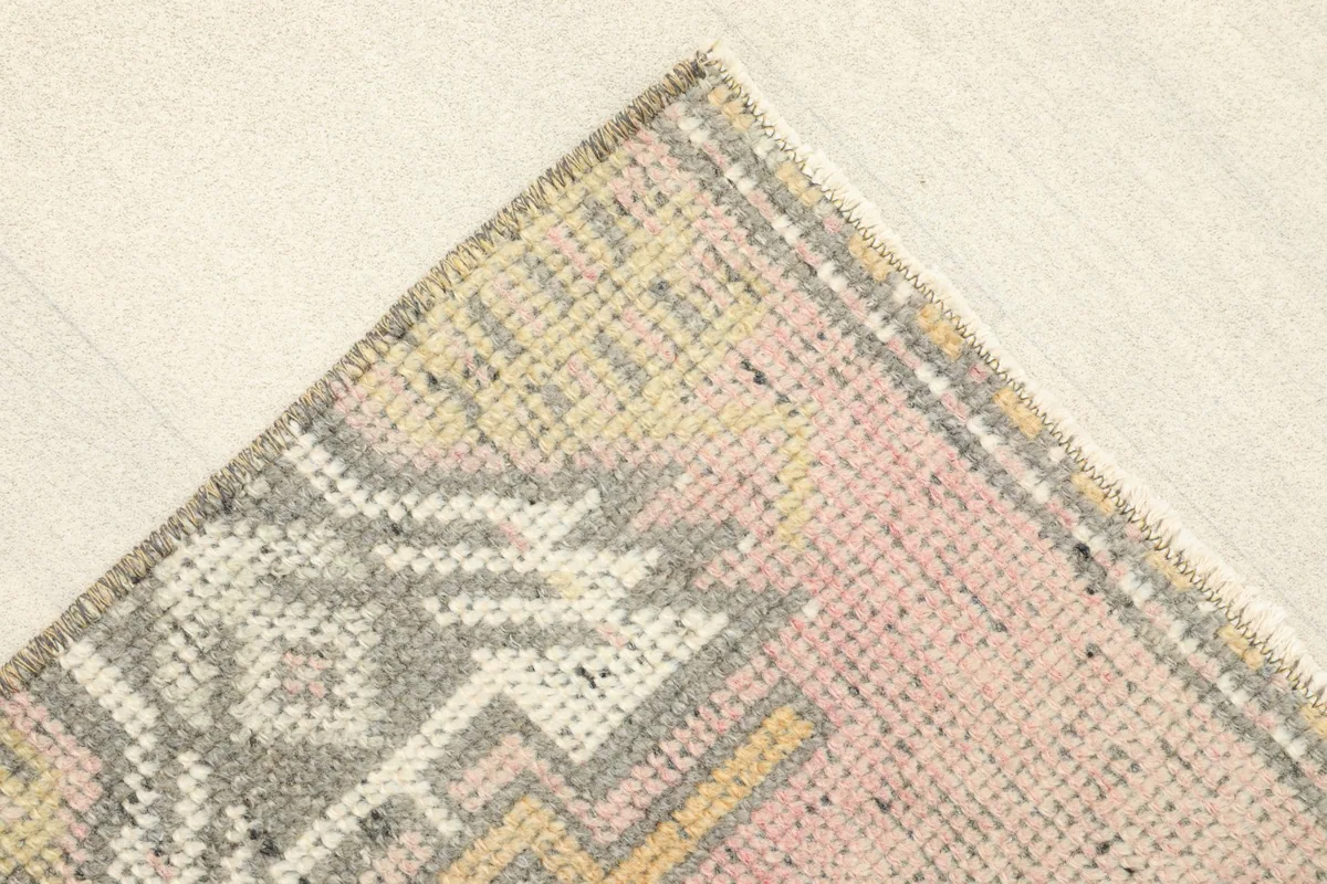 Close-up of the upper left corner of the rug, showing the wool pile and edge finishing.