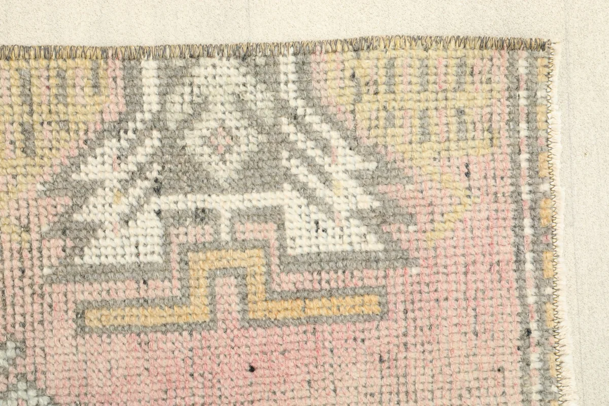 Close-up of the upper right corner, detailing the geometric motifs and the rug's texture.