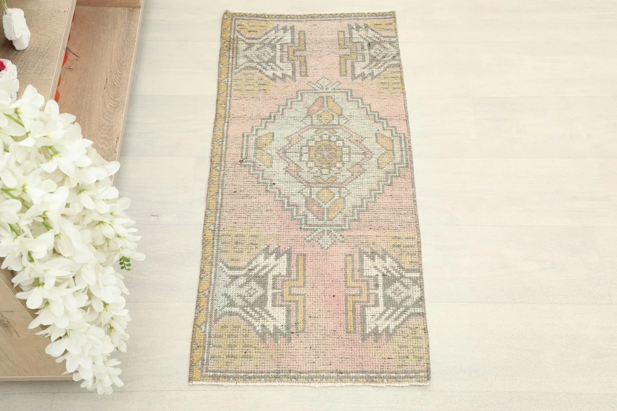 Overhead view showcasing the full rose rug with gold and gray geometric patterns.