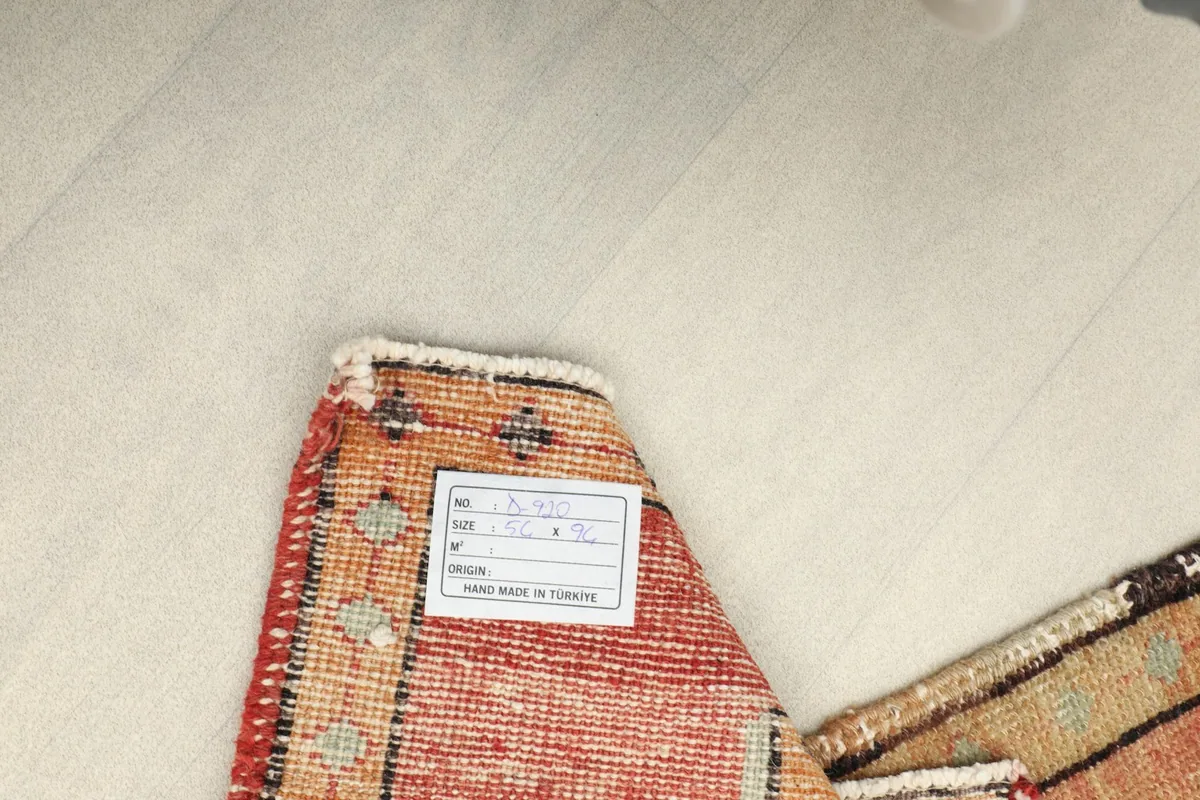 Close-up of the back of the rug with a label, showing the tight hand-knotting on the cotton foundation.