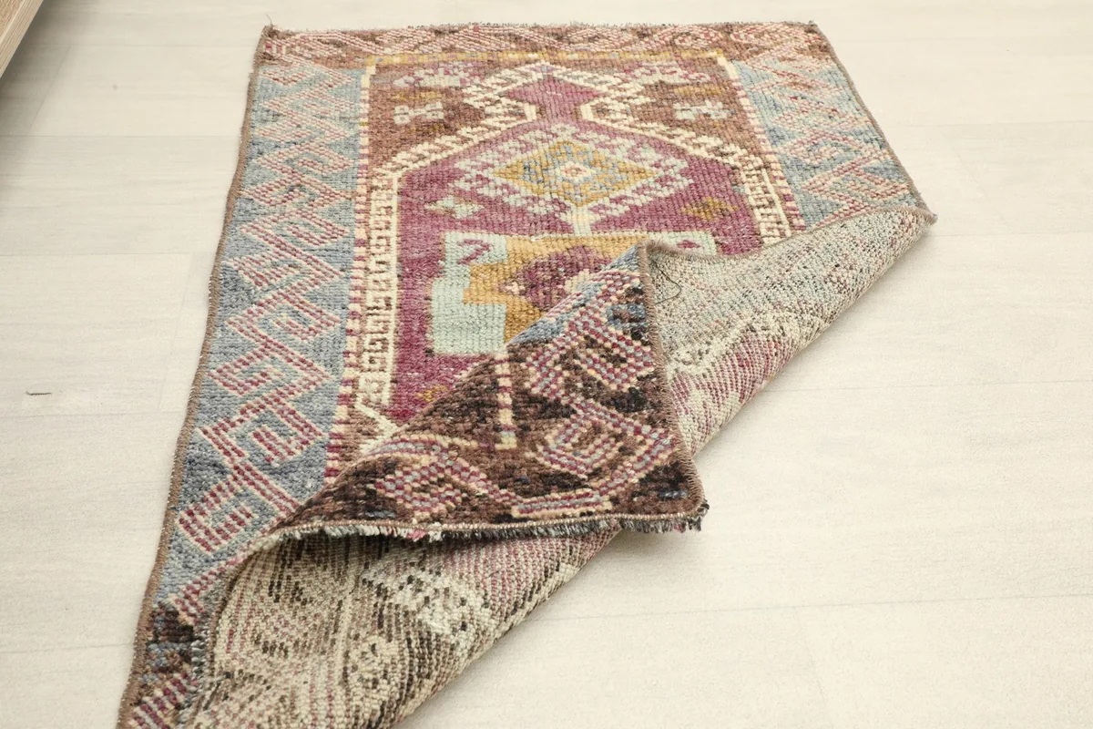 Rug folded to show its thickness and the reverse side, emphasizing its pliable nature.