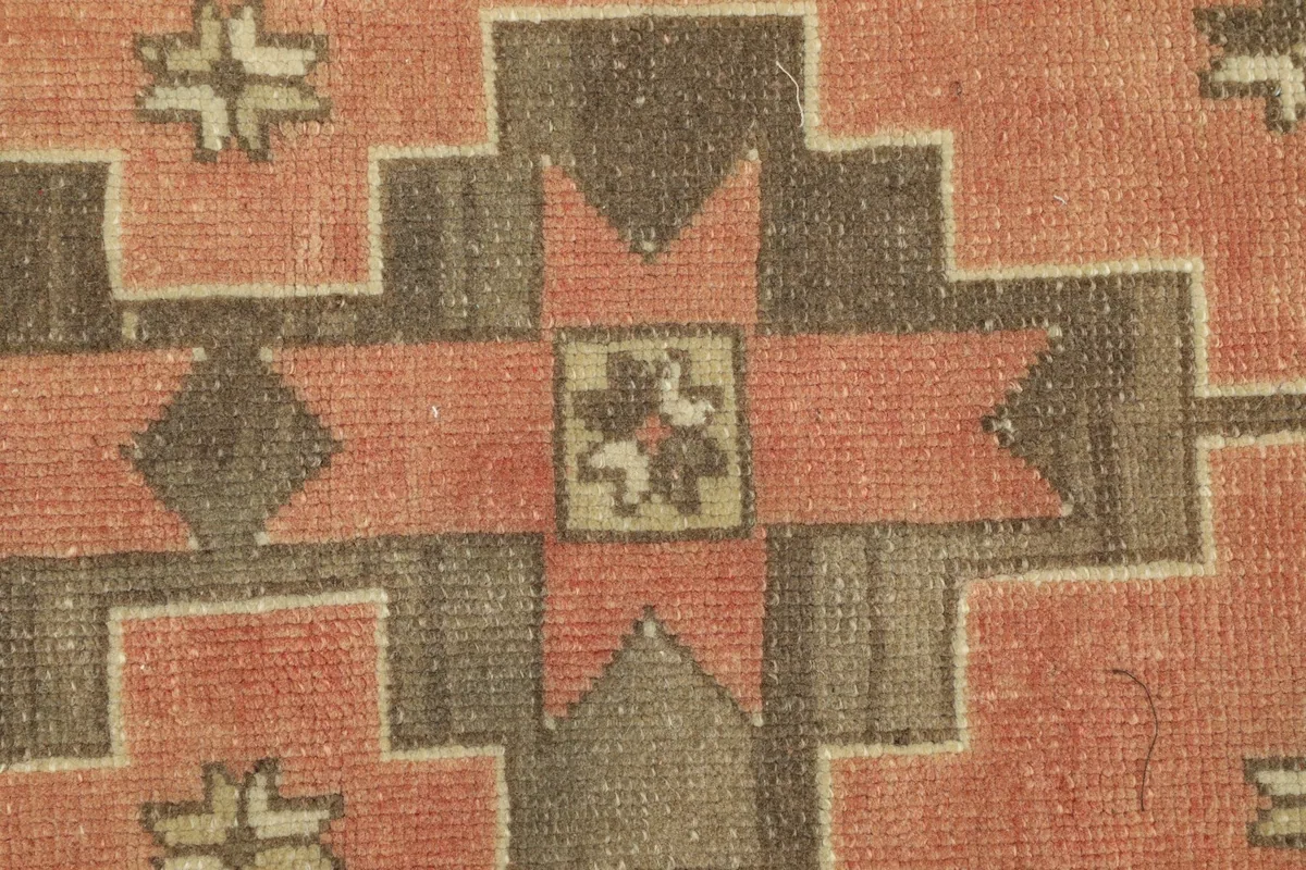 Close-up detail of the hand-knotted wool pile and a central geometric star motif.