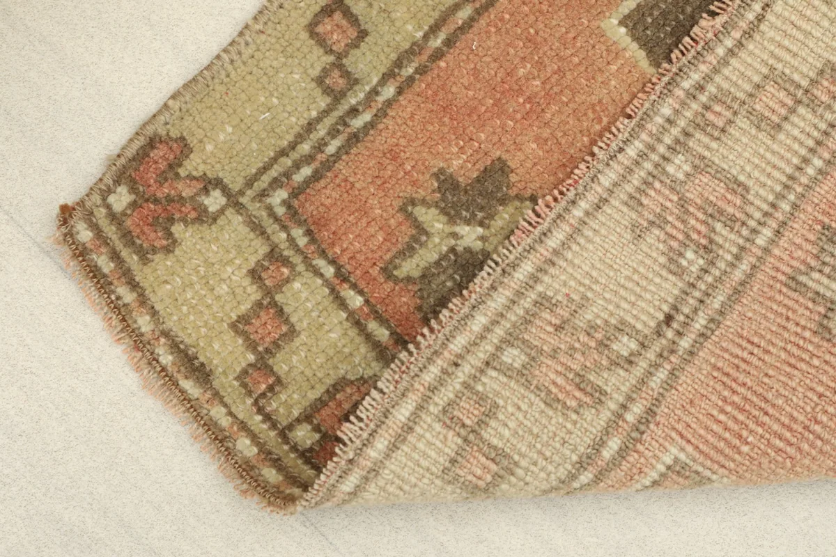 View of the rug's low wool pile and the hand-knotted cotton foundation visible from the side.