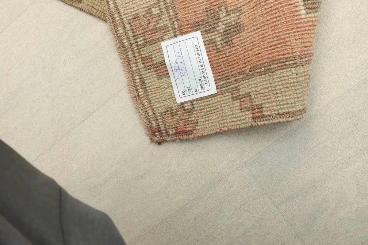 Close-up of the back of the rug, showing the knotting and a product label.