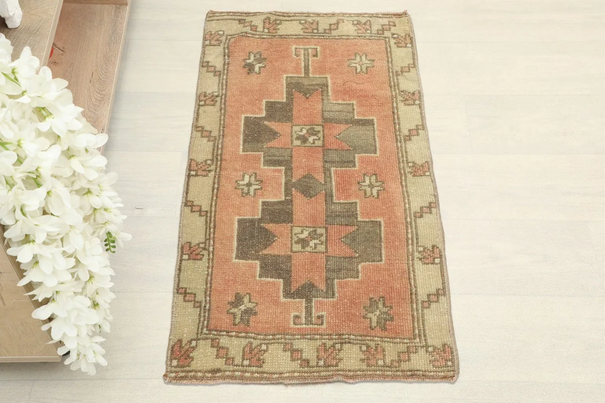 Direct overhead view of the rust geometric rug, showing the central tribal pattern and beige border.