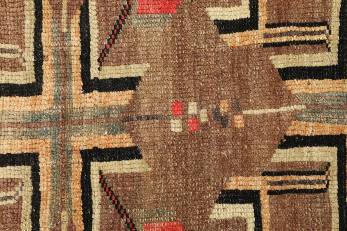 Close-up detail of the hand-knotted wool pile and a central geometric design element.