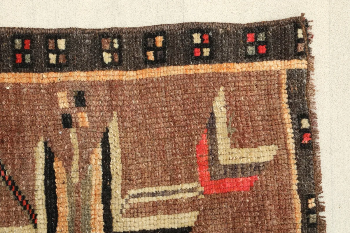 Detailed view of the rug's edge, showcasing the texture and color variations in the border.