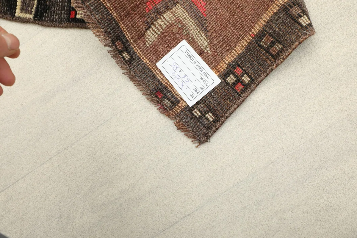 View of the rug's back, showing the label and the tightly woven cotton foundation.