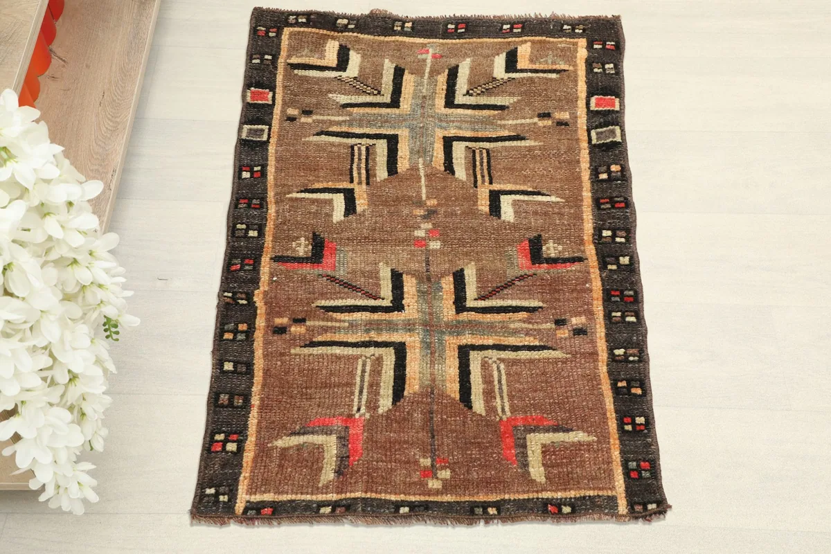 Overhead view of the brown vintage rug, showing its full geometric pattern.