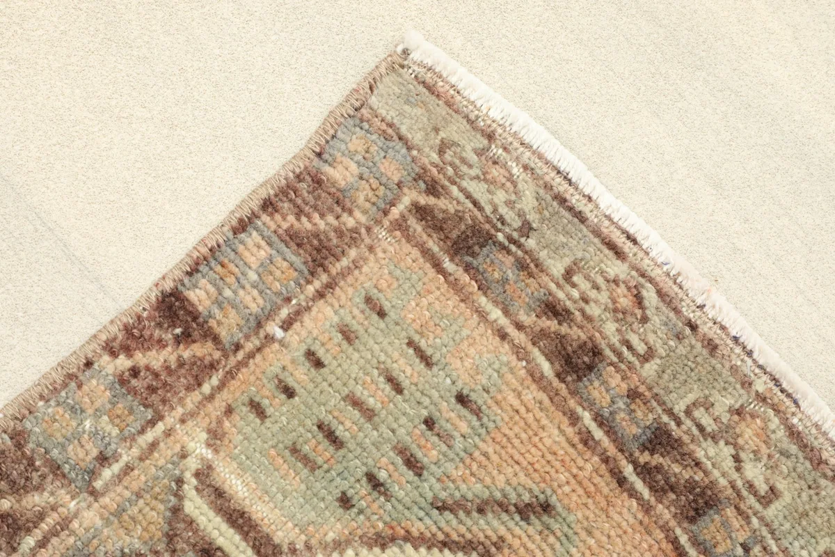 Angled view of a corner of the rug, showing the wool pile and cotton foundation.