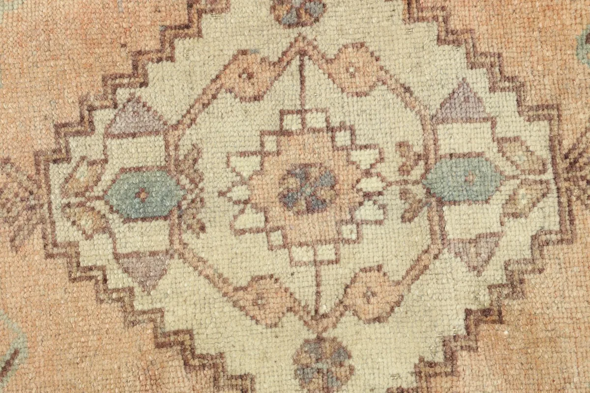 Detailed view of the intricate hand-knotted patterns and color variations in the rug's center.