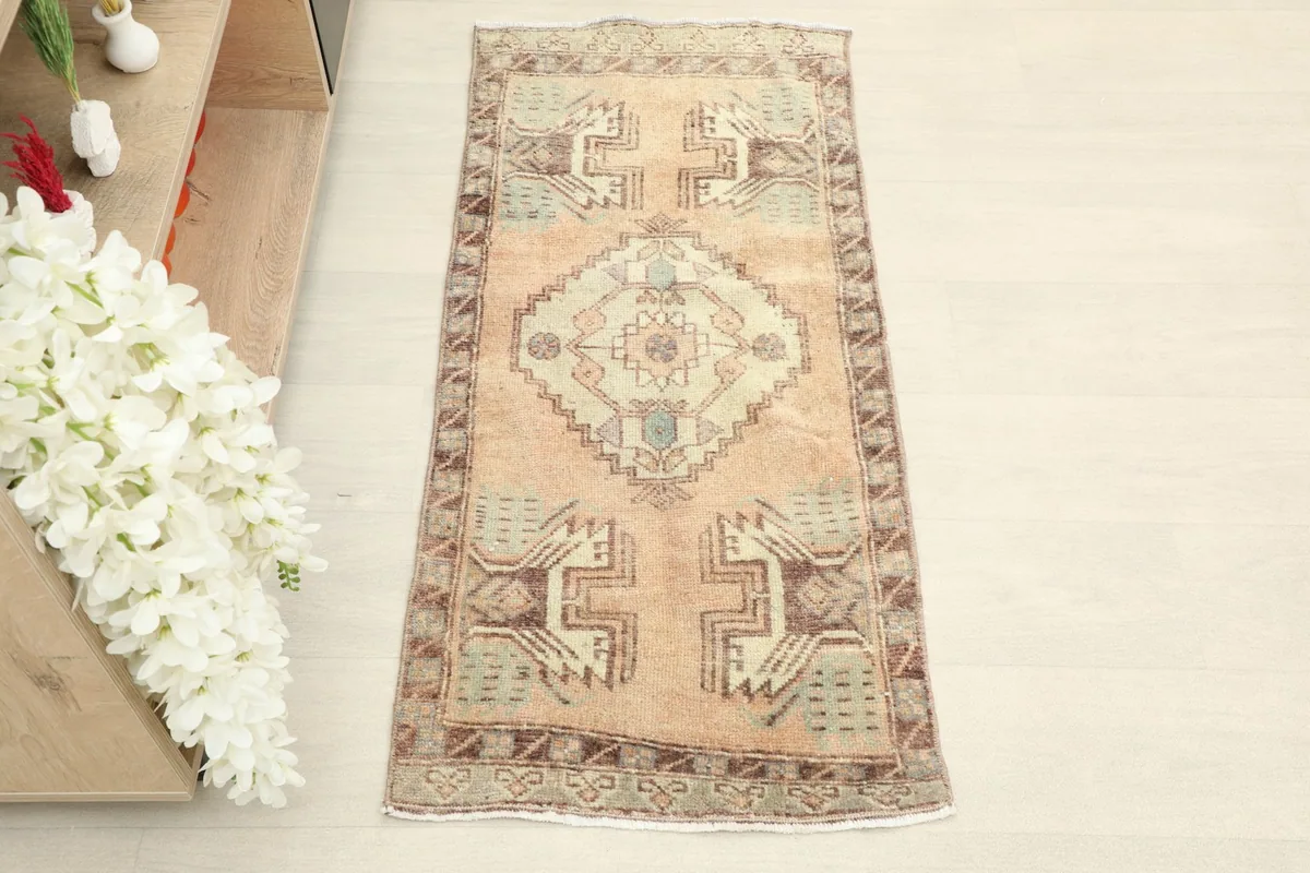 Overhead view of the tan and olive vintage Anatolian rug, showcasing its geometric patterns.