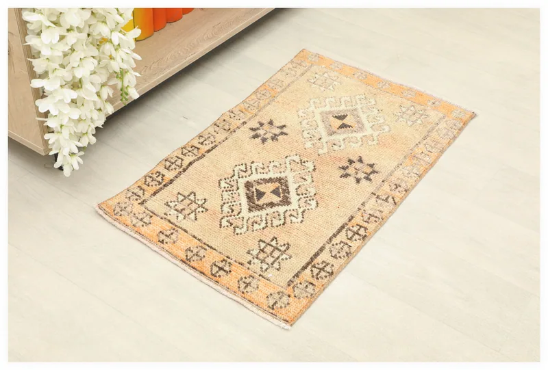 Full top view of a beige and orange geometric vintage Anatolian rug on a white background.
