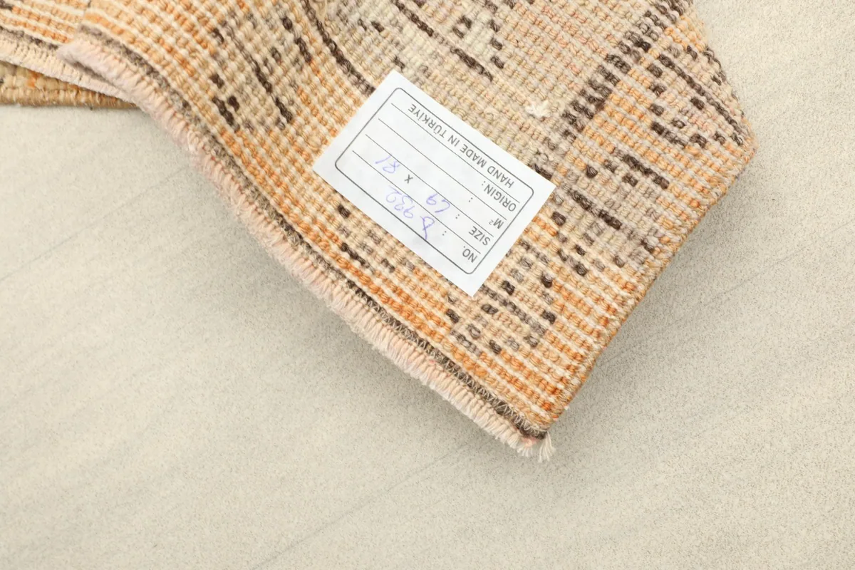Close-up of the back of the rug, showing the hand-knotted cotton foundation and a product label.