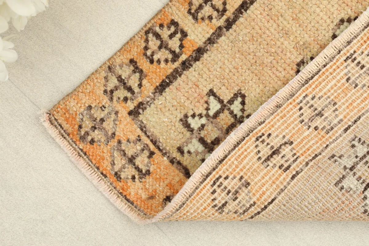 Partial fold of the rug revealing the wool pile texture and the cotton foundation.