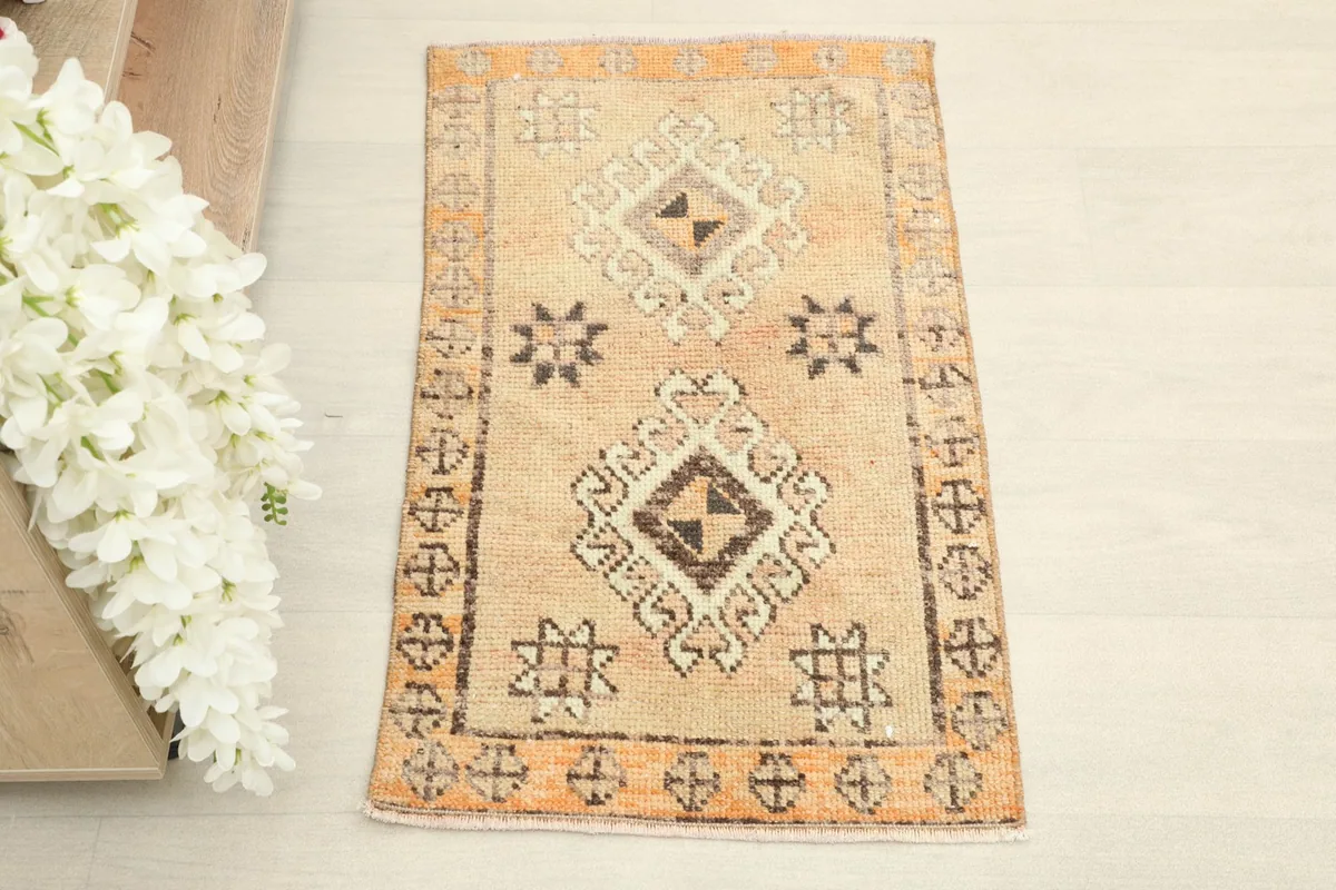 Overhead shot showing the full pattern of the beige and orange hand-knotted rug.