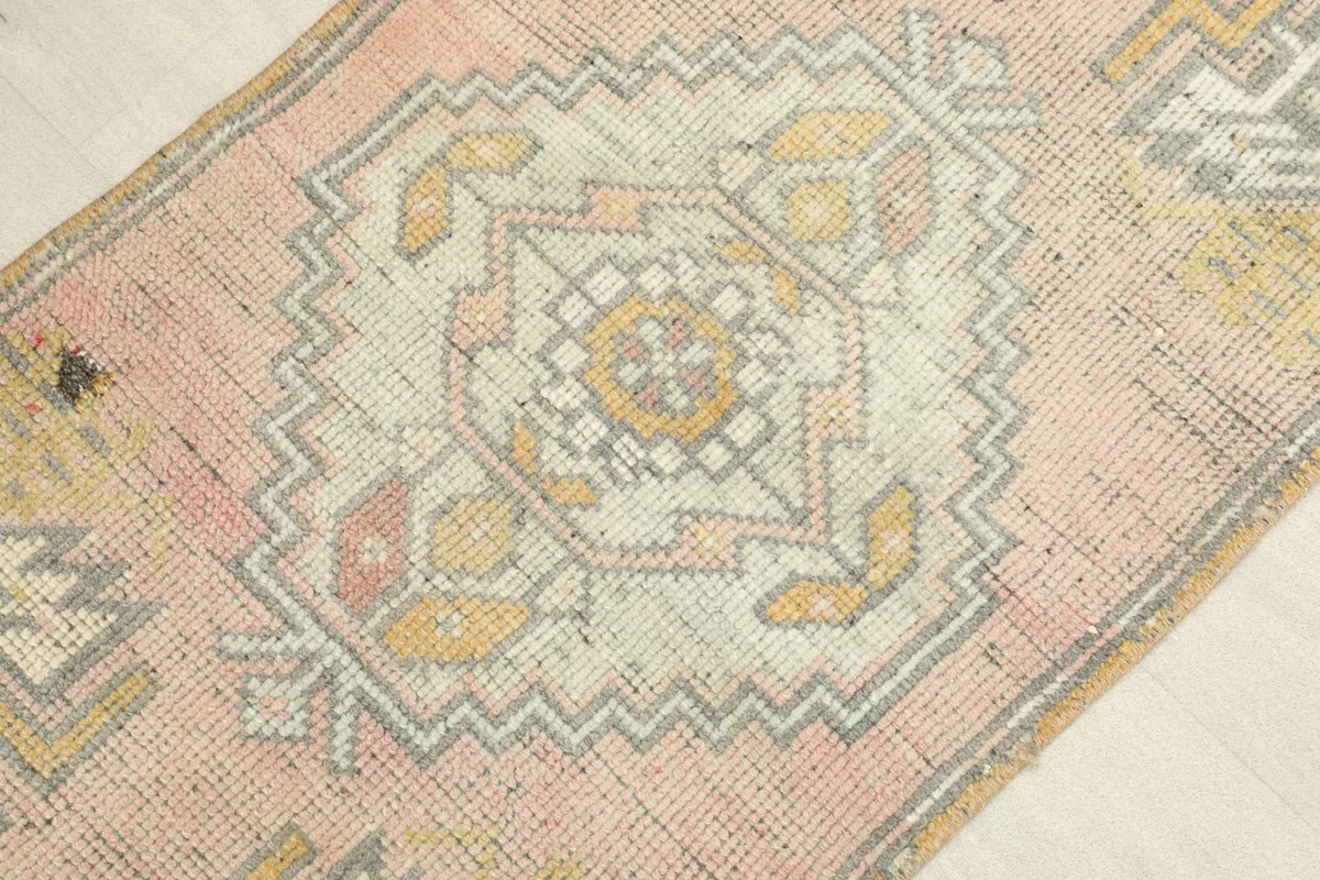 Angled close-up view of the rug's center, highlighting the main medallion and surrounding motifs.