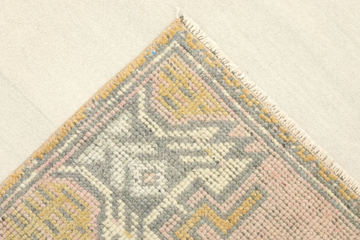 Close-up of a corner of the rug, showing the geometric border design and fringe details.