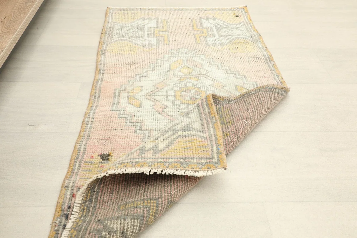 The rug partially folded, displaying both the pile side and the back of the rug.
