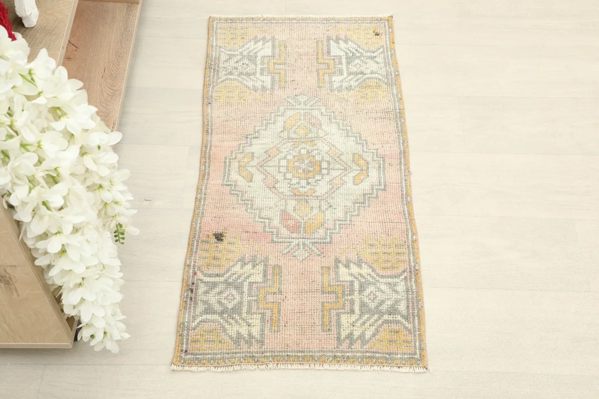 Overhead view of the vintage pink rug, showcasing its full geometric pattern and colors.