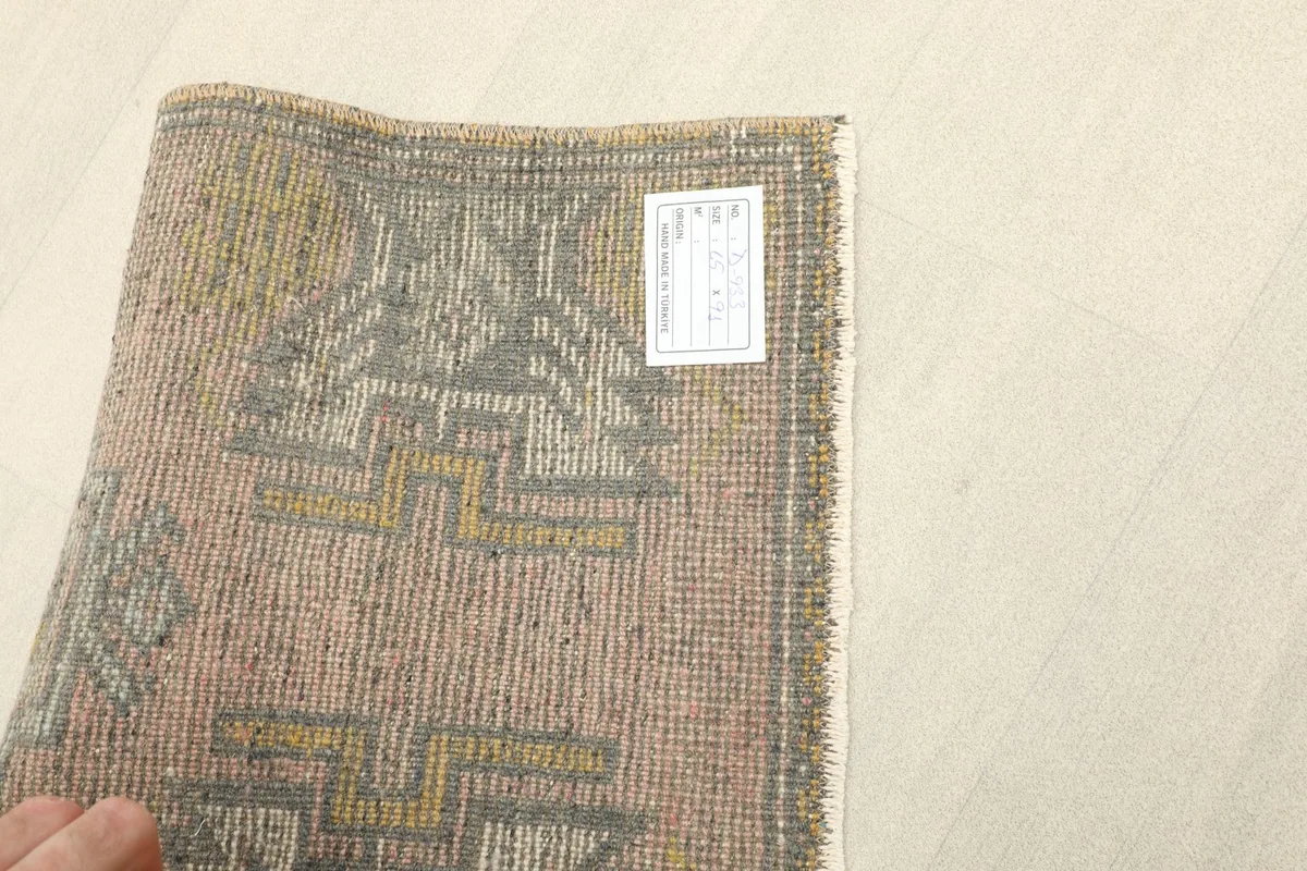 Close-up of the back of the rug with a label, showing the tight knotting and foundation.