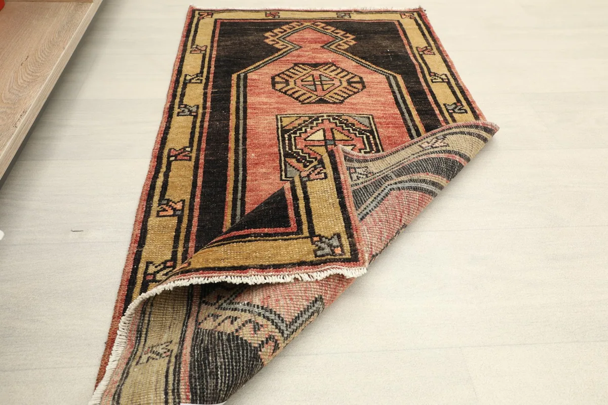 The rug partially folded, displaying the full design and the reverse side of the hand-knotted construction.