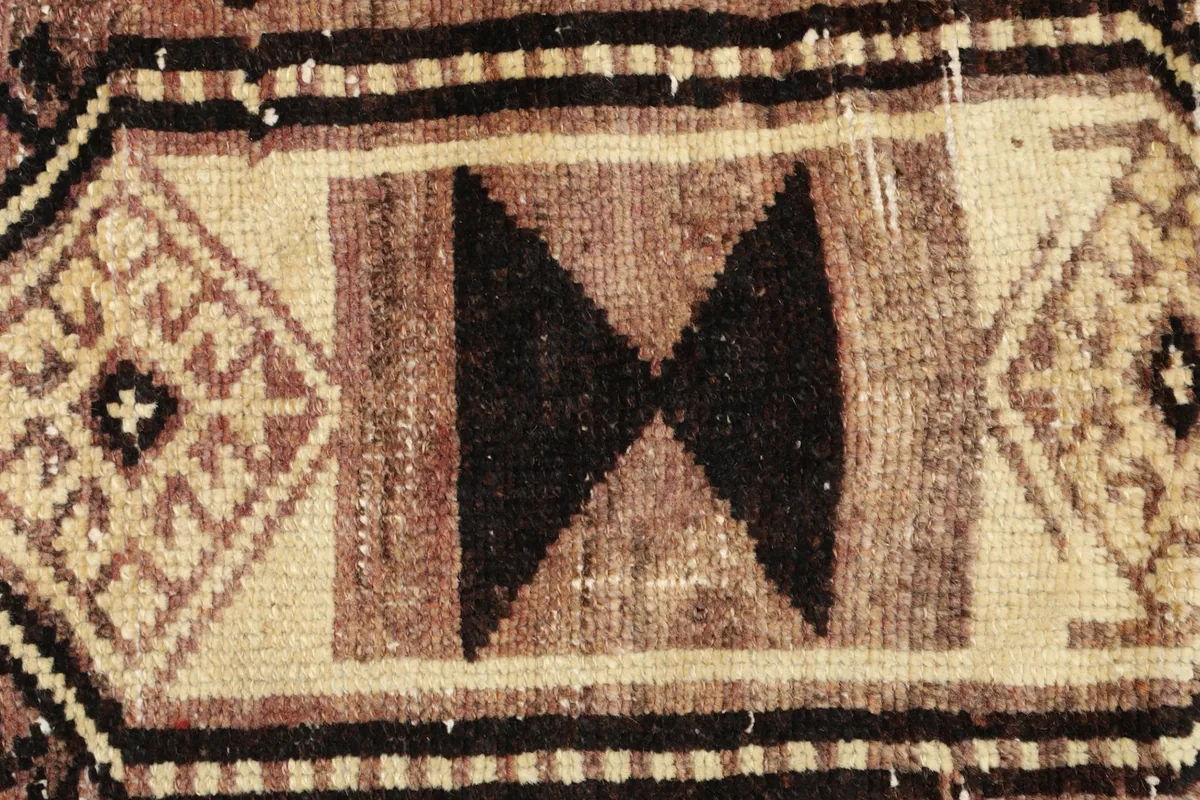Close-up of the central brown and beige geometric motif with black accents