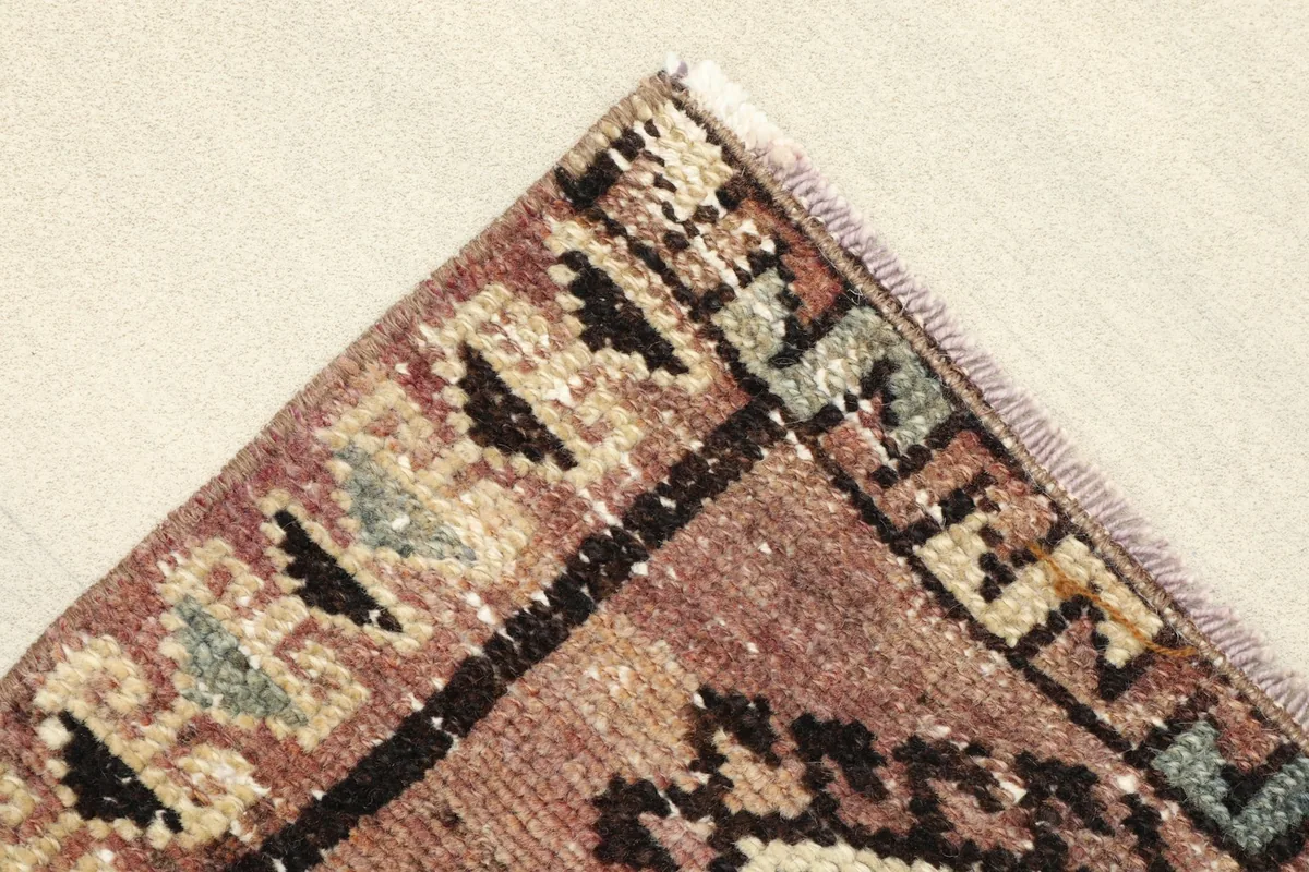 Detail of the rug's border with small geometric shapes and fringe