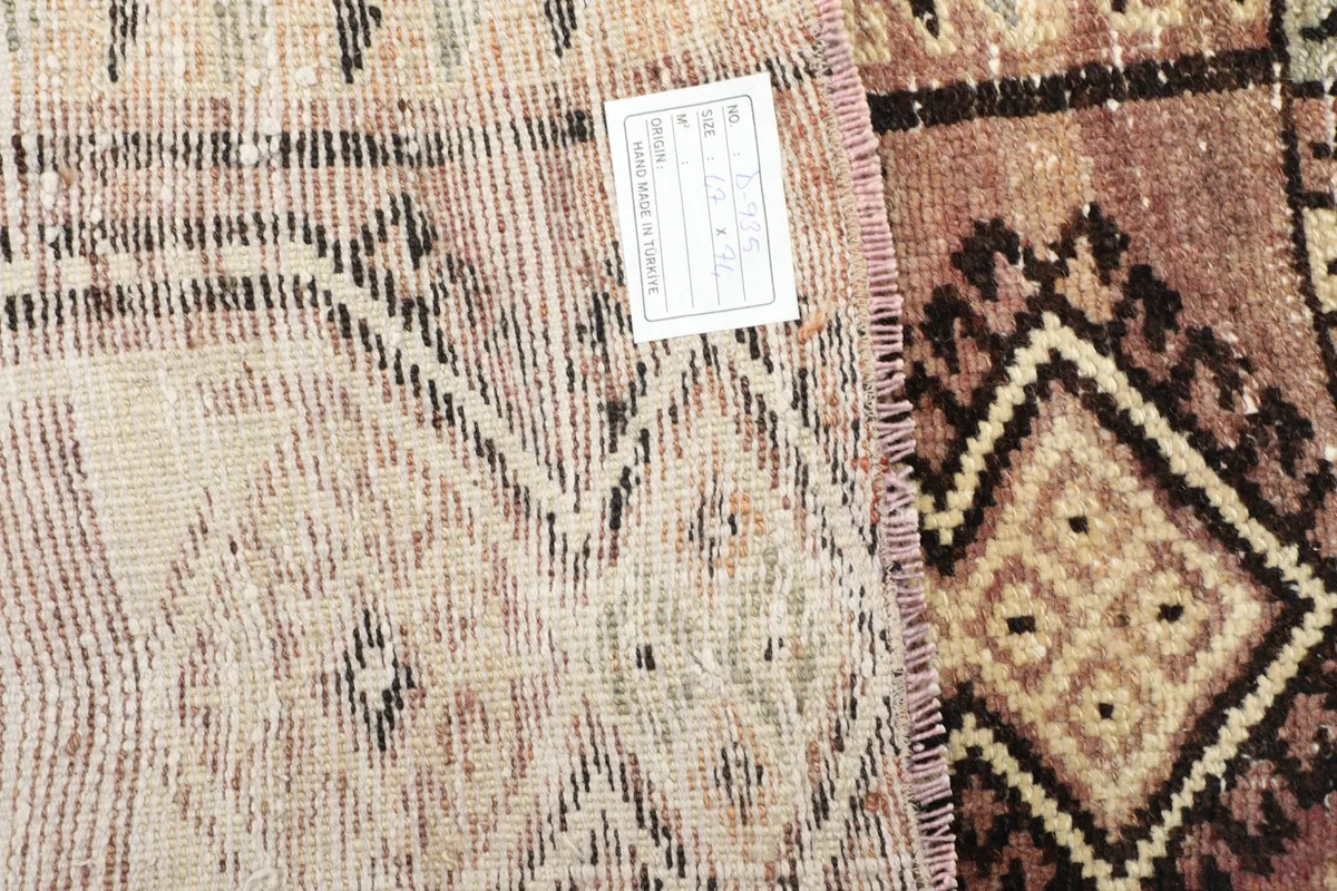 View of the reverse side of the rug, showing the knotting and a product label