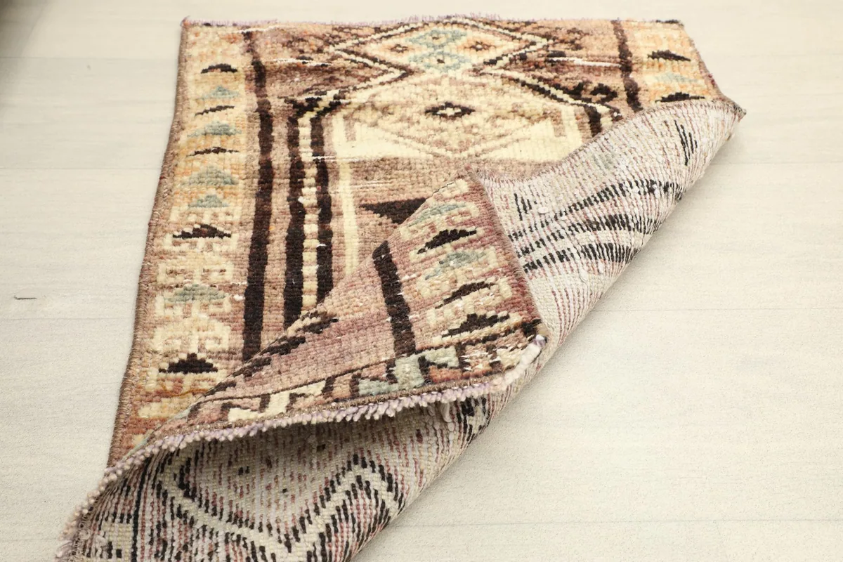 Rug partially folded, revealing the reverse side and the hand-knotted construction