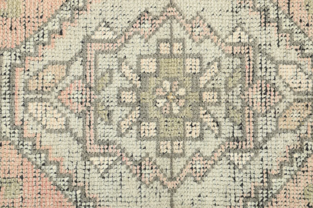 Detailed shot of the wool pile and intricate geometric patterns on the vintage Anatolian rug.