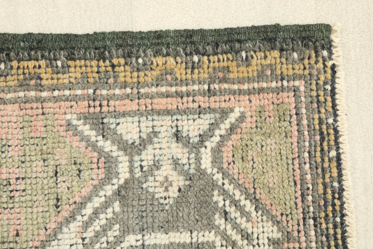 Edge detail of the rug, displaying the hand-knotted texture and color variations in the border.