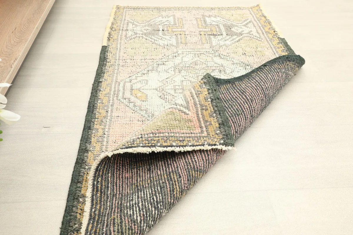 The rug partially folded, revealing the reverse side and the craftsmanship of the hand-knotted construction.